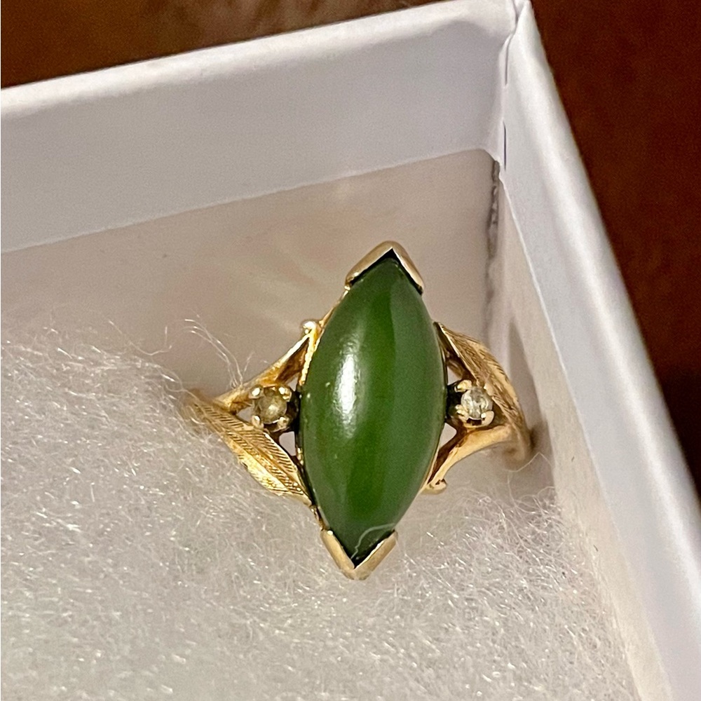 A genuine spinach green Nephrite jade stone with two diamonds in 10K gold.
